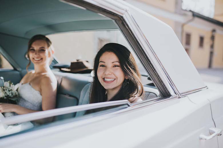 recently married same-sex couple sitting in wedding car