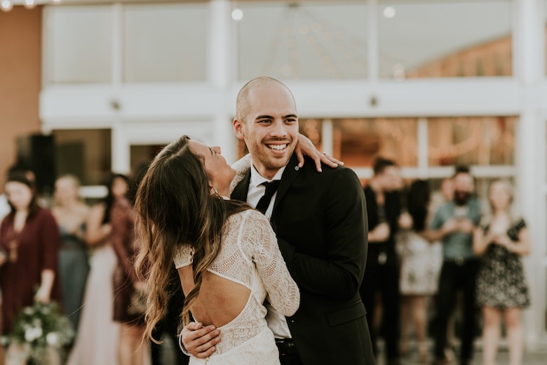 bride and groom laugh while out on the dance floor