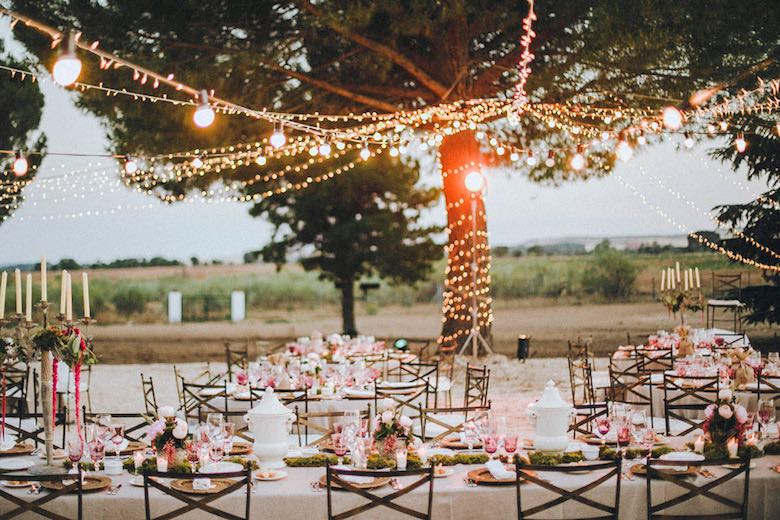 outdoor table setting with flowers and string lights