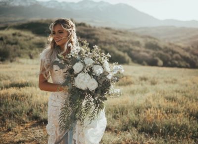 bride holding bouquet on hillside