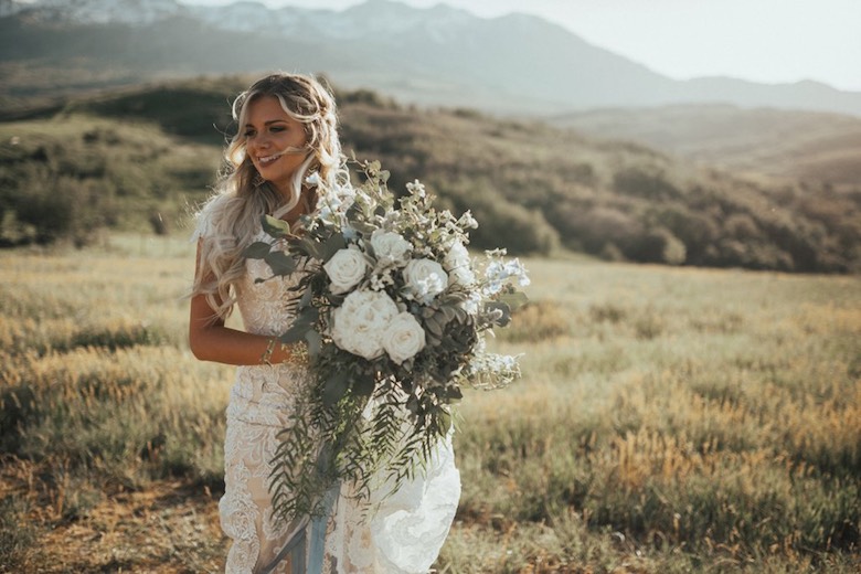 bride holding bouquet on hillside