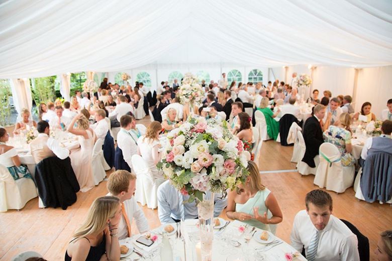 guests enjoying a outdoor wedding rehearsal dinner in a tent