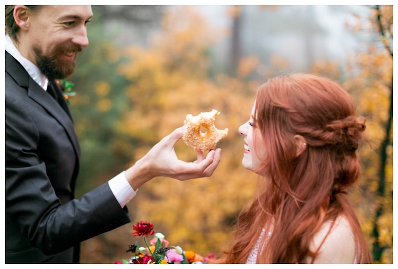 bride and groom sharing a donut 