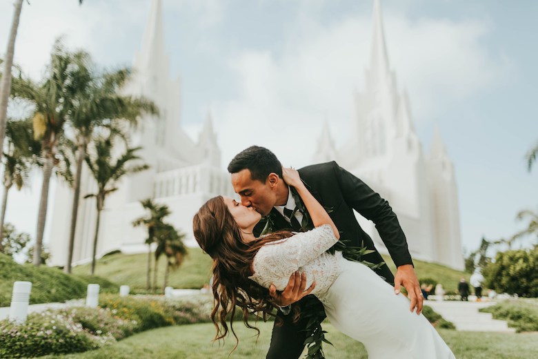 recently engaged couple kissing passionately in front of a white chapel