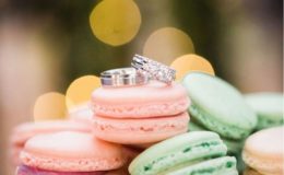 tower of macarons with wedding bands on top