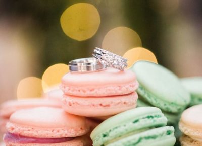 tower of macarons with wedding bands on top