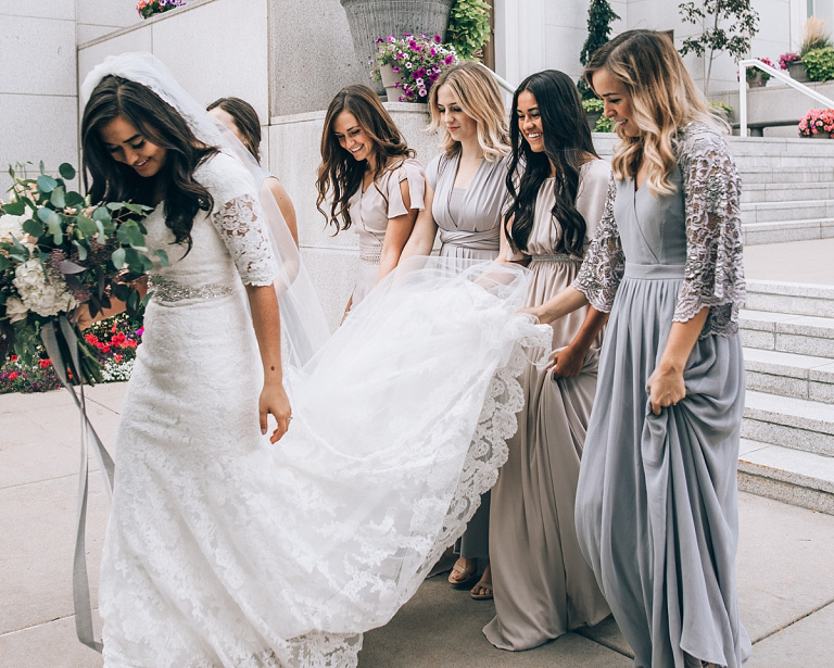 Bridesmaids holding bride's train